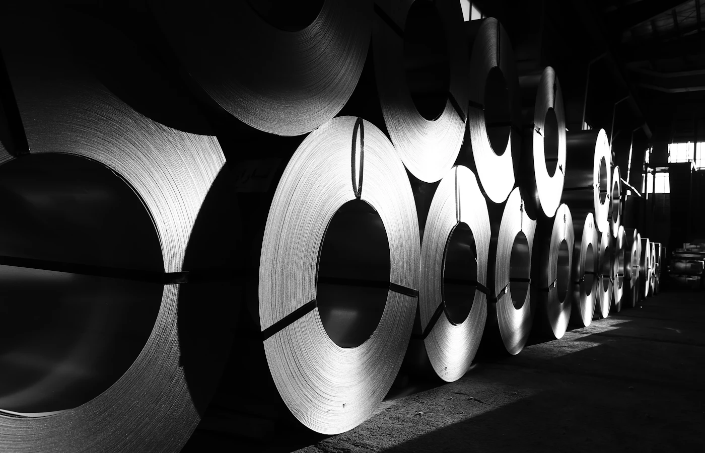 Rolls of steel sheet lined up in a warehouse